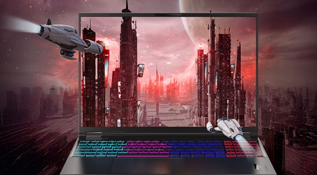 Laptop z wyświetlaczem przedstawiającym futurystyczne miasto z wysokimi wieżowcami i dwoma statkami kosmicznymi. Klawiatura laptopa podświetlona jest w różnych kolorach.