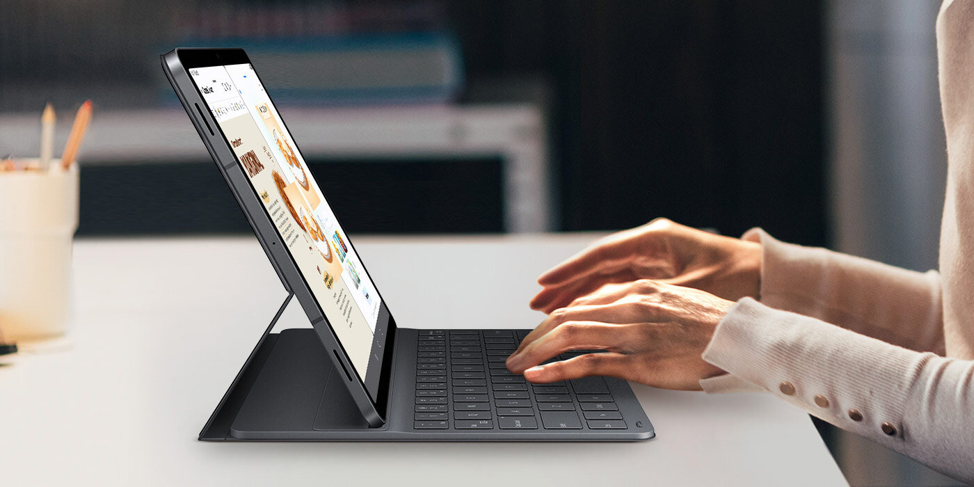 Użytkownik pisze na Galaxy Tab S11 za pomocą klawiatury Book Cover Keyboard Slim. Na ekranie wyświetlane są obok siebie aplikacje Drawing Assist i Samsung Notes. Smukła konstrukcja klawiatury idealnie dopełnia design tabletu, podkreślając jego elegancki, profesjonalny wygląd, idealny do kreatywnej pracy wielozadaniowej.