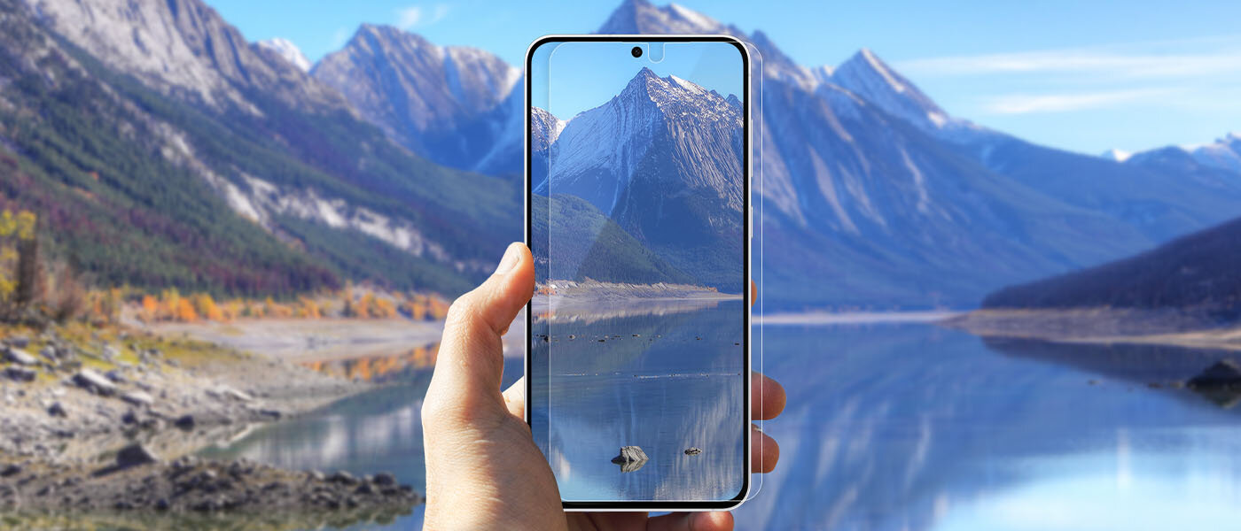 Lewa ręka trzyma Galaxy S25 FE z powłoką antyrefleksyjną - telefon skierowany w stronę pięknego krajobrazu gór i jeziora. Na wyświetlaczu telefonu widać tę scenerię. Lewa ręka trzyma Galaxy S25 FE z powłoką antyrefleksyjną - telefon skierowany w stronę pięknego krajobrazu gór i jeziora. Na wyświetlaczu telefonu widać tę scenerię.