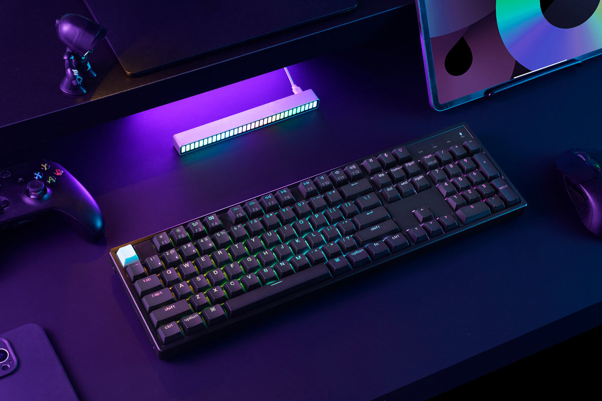 KEYCHRON K10 HE Tryb 2,4 GHz z częstotliwością odświeżania 1000 Hz Bluetooth 5.2 do trzech urządzeń jednocześnie USB‑C stabilne połączenie i zasilanie magnetyczny odbiornik 2.4 GHz USB-A - klawiatura na biurku obok kontroler