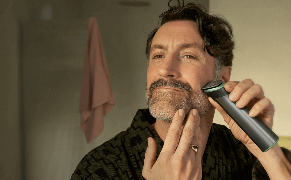 Mężczyzna trzyma w ręce urządzenie multigroom