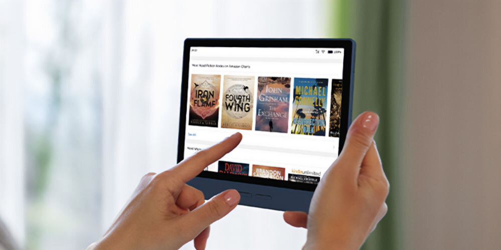 Czytnik e-booków BIGME B7 CL 4G 7 cali, Podświetlany ekran, Wi-Fi Granatowy czytnik trzymany w rękach z włączoną aplikacją z książkami rozmazane tło