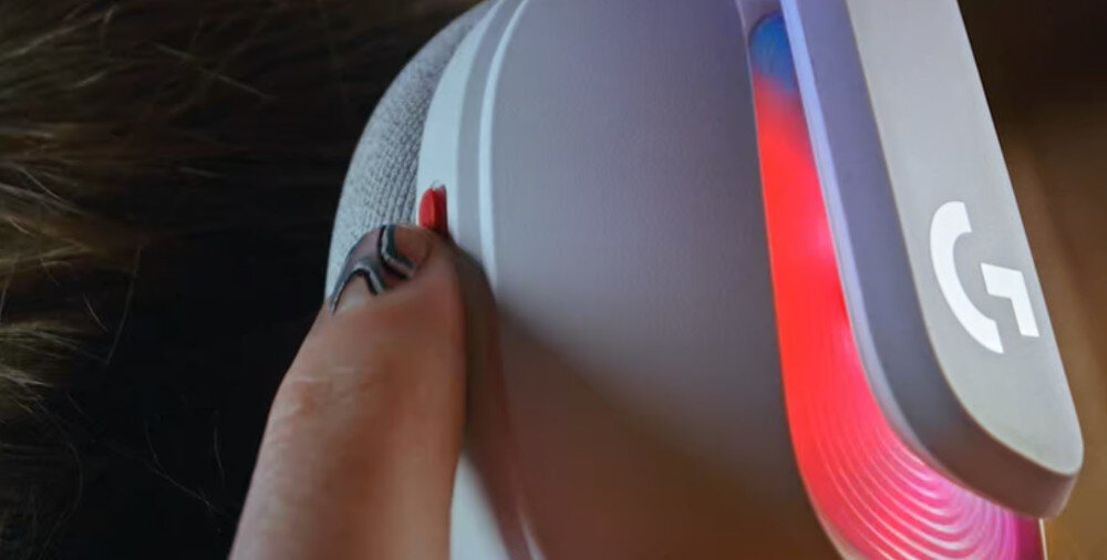 Słuchawki LOGITECH A20 X PlaySync Audio przełączanie konsol Xbox PS5 PC, osoba z założonymi słuchawkami dotykająca palcem przycisku