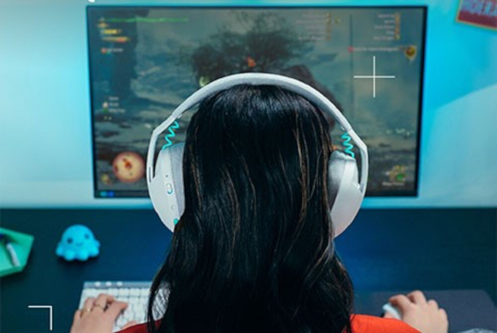 Słuchawki LOGITECH G321 przetworniki audio przestrzenny dźwięk w grach, osoba z założonymi słuchawkami gamingowymi siedząca przed komputerem