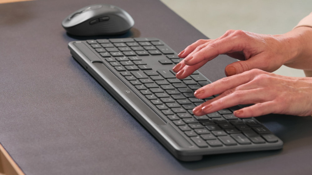 LOGITECH Slim Solar+ naturalne i ciche pisanie laptopa układ klawiszy stabilna konstrukcja - osoba pisząca na klawiaturze