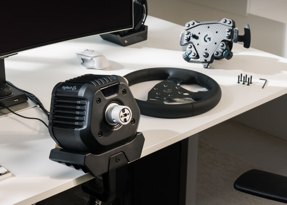 Kierownica LOGITECH RS50 (PC/Playstation) prezentacja kierownicy rozłożonej na części na biurku obok monitor kompletny zestaw symulatory wyścigowe napęd Direct Drive moment obrotowy TRUEFORCE odwzorowanie wrażeń wyścigi