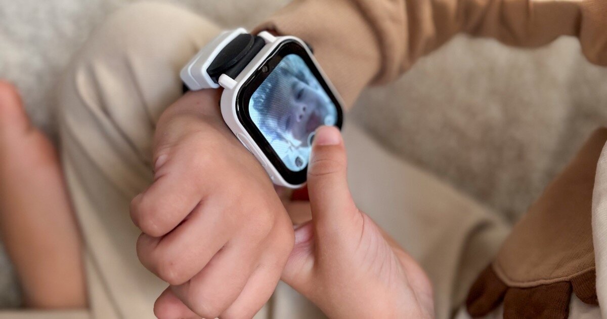 Smartwatch KIDIZ Chat 2.1 Dziecko używa smartwatcha KiDiZ Watch z czarnym paskiem, bawiąc się aparatem na zegarku.