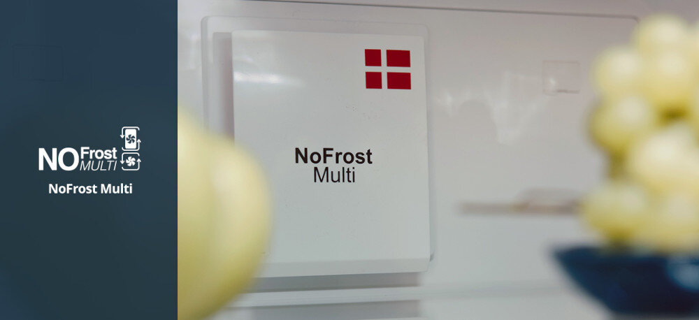 Lodówka VESTFROST VR-BB27633H0DD Zdjęcie przedstawia wnętrze chłodziarki z panelem NoFrost Multi Cooling na tylnej ściance oraz kilkoma przeźroczystymi półkami i uchwytami na butelki. Widać gładką metaliczną ściankę chłodzącą oraz czytelnie oznaczony moduł NoFrost Multi na środku komory Dwa niezależne obiegi powietrza zapewniają równą temperaturę, brak szronu i brak przenikania zapachów