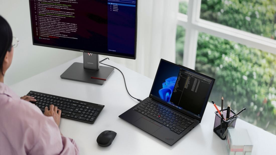Osoba pracuje na laptopie Lenovo ThinkPad z aplikacją Lenovo Vantage podłączonym do monitora w uporządkowanym stanowisku biurowym - LENOVO Vantage i zarządzanie flotą 