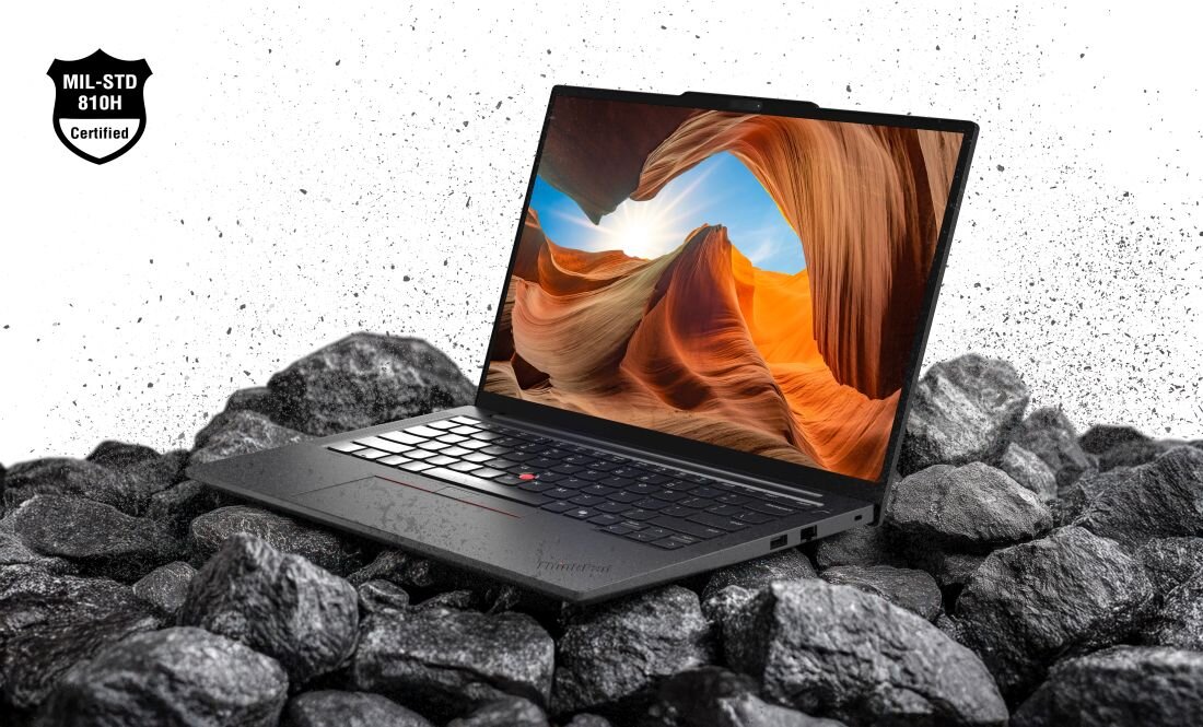 Laptop Lenovo ThinkPad z certyfikatem MIL-STD-810H stoi na kamieniach, prezentując wytrzymałą konstrukcję w wymagającym środowisku pracy - Wytrzymałość MIL-STD-810H 