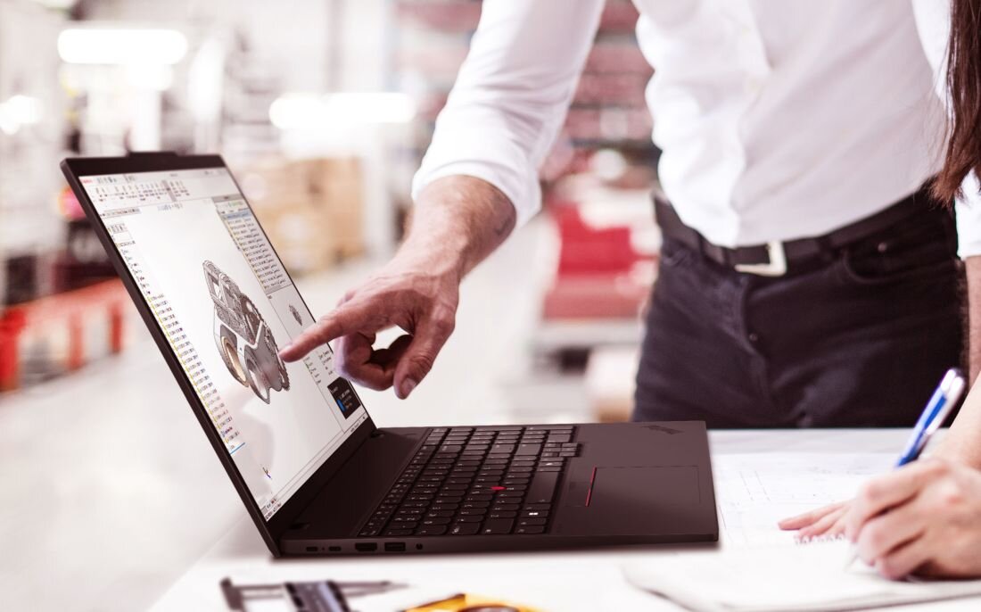 Zespół projektantów współpracuje przy laptopie Lenovo ThinkPad z DDR5 podczas tworzenia modelu 3D w laboratorium produkcyjnym. - DDR5 Dysk SSD 