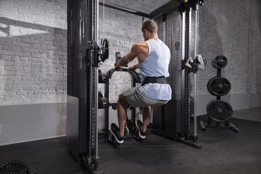 Brama do ćwiczeń INSPIRE FITNESS FT2 PRO + Ławka FID7.1 pomieszczenie siłownia brama na tle ceglanej ściany osoba ćwiczy dwa stosy po 75 kg z przełożeniem oferują płynną regulację oporu można dobrać ciężar do swoich możliwości trening jest bezpieczny i komfortowy precyzyjna mechanika wpływa na kontrolę ruchu zwiększa efektywność ćwiczeń