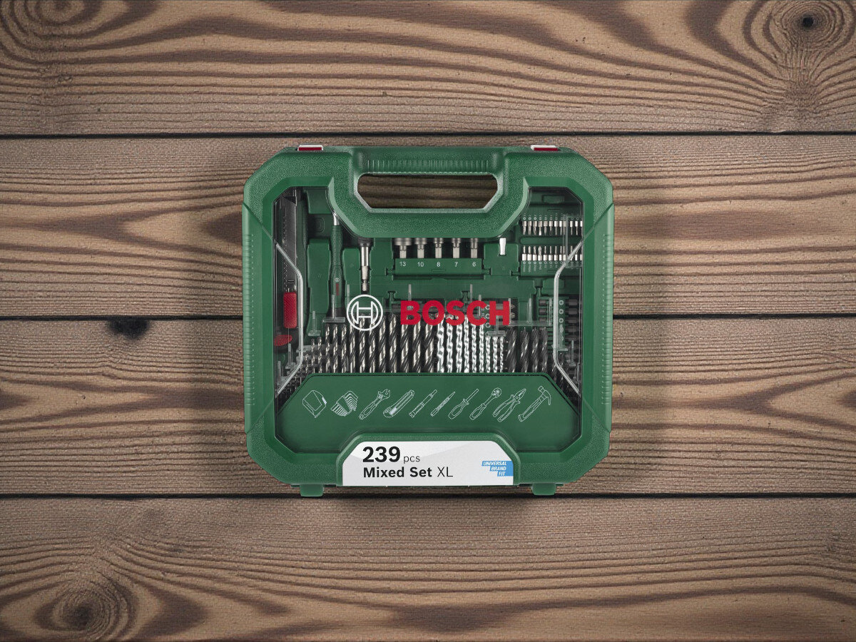Zestaw wierteł i bitów BOSCH Mac Gyver Mixed Set XL (239 szt.), zestaw wiercenie, wkręcanie, bosch xl, walizka, zestaw zamknięty stoi pionowo na blacie drewnianym w tle ceglana ściana