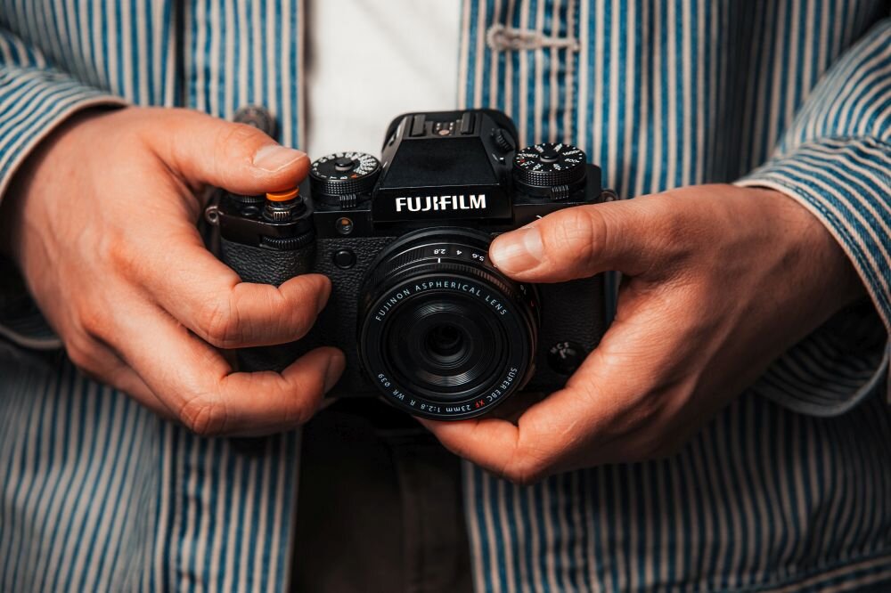 FUJIFILM XF 23 mm f-2.8 R WR kompaktowy obiektyw 90g lekka konstrukcja mobilność aparat w rękach 