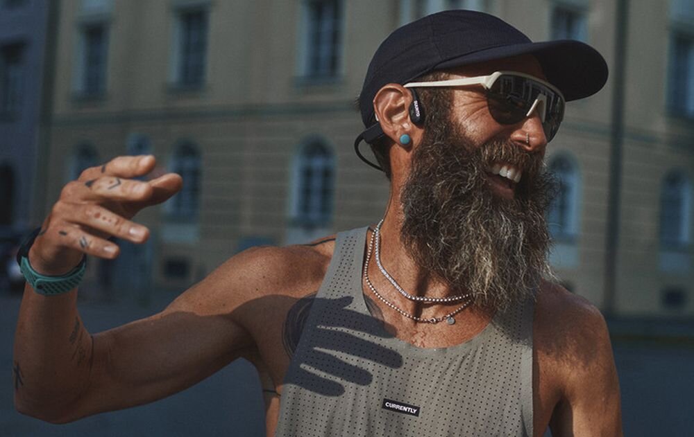 Słuchawki SUUNTO Wing 2 premium z przewodnictwem kostnym, powerbankiem i technologią open-ear do aktywności outdoor, osoba z założonymi słuchawkami kostnymi