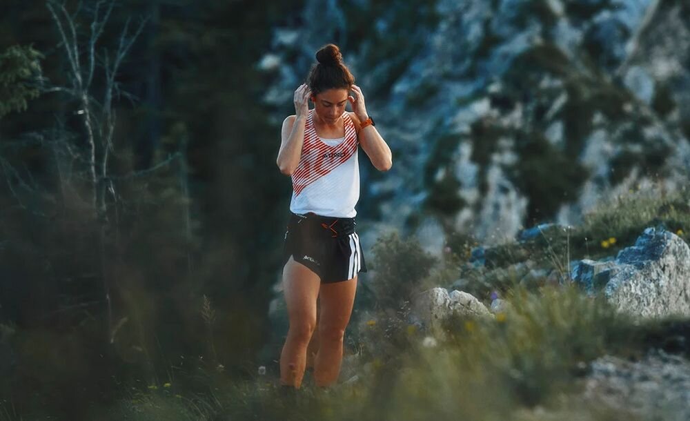 Słuchawki SUUNTO Wing 2 wysoka jakość dźwięku mikrofon redukcja wiatru do 30 km/h rozmowy podczas biegu, osoba z założonymi słuchawkami kostnymi