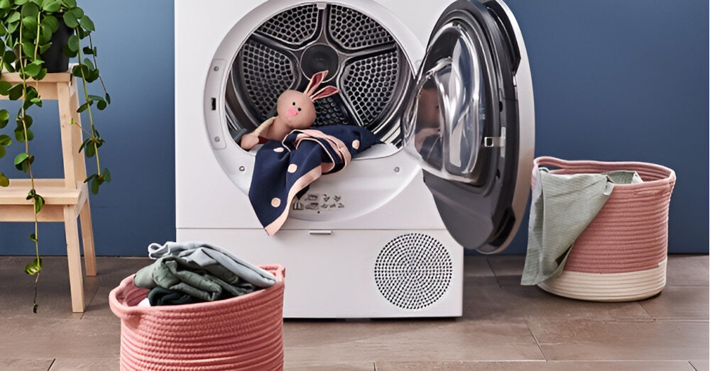 SUSZARKA BOSCH WQG243MSPL Na zdjęciu znajduje się suszarka bębnowa z otwartymi drzwiami. W bębnie leży pluszowy królik oraz dziecięce ubranka. Przed suszarką stoją dwa różowe, tekstylne kosze na pranie – jeden z ubraniami, drugi z ręcznikiem. Po lewej stronie widoczna jest roślina doniczkowa na drewnianym stojaku. Całość prezentuje przytulną i uporządkowaną przestrzeń pralnianą system sensitivedrying delikatne suszenie ochrona tkanin suszenie wełny suszenie jedwabiu równomierne suszenie mniej zagnieceń miękkie i świeże pranie suszarka bosch