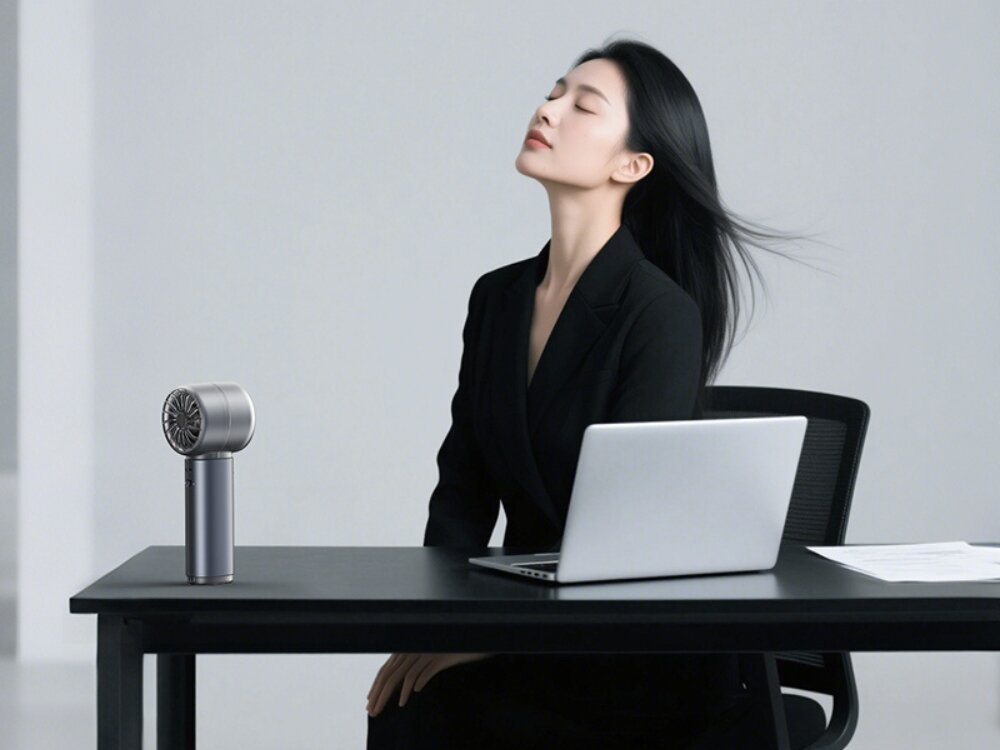 LIFEUSAMS LU03 wyświetlacz LED Elegancka kobieta w czarnym żakiecie siedząca przy biurku z laptopem, korzystająca z grafitowego wentylatora stojącego USAMS.