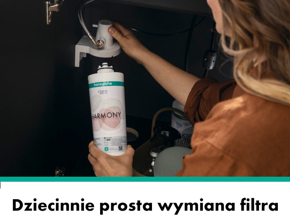Osoba wymienia filtr w systemie pod zlewem, trzymając wkład z napisem \'hansgrohe claro HARMONY\'. Na dole obrazu widnieje tekst: \'Dziecinnie prosta wymiana filtra\'.