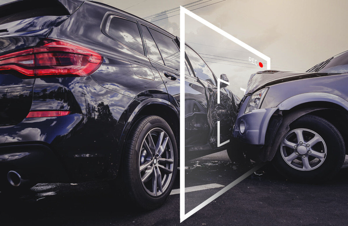 Dwa samochody stojące blisko siebie, z widocznymi uszkodzeniami na jednym z nich. Na obrazie znajduje się symbol kamery z napisem \'REC\' i czerwoną kropką.