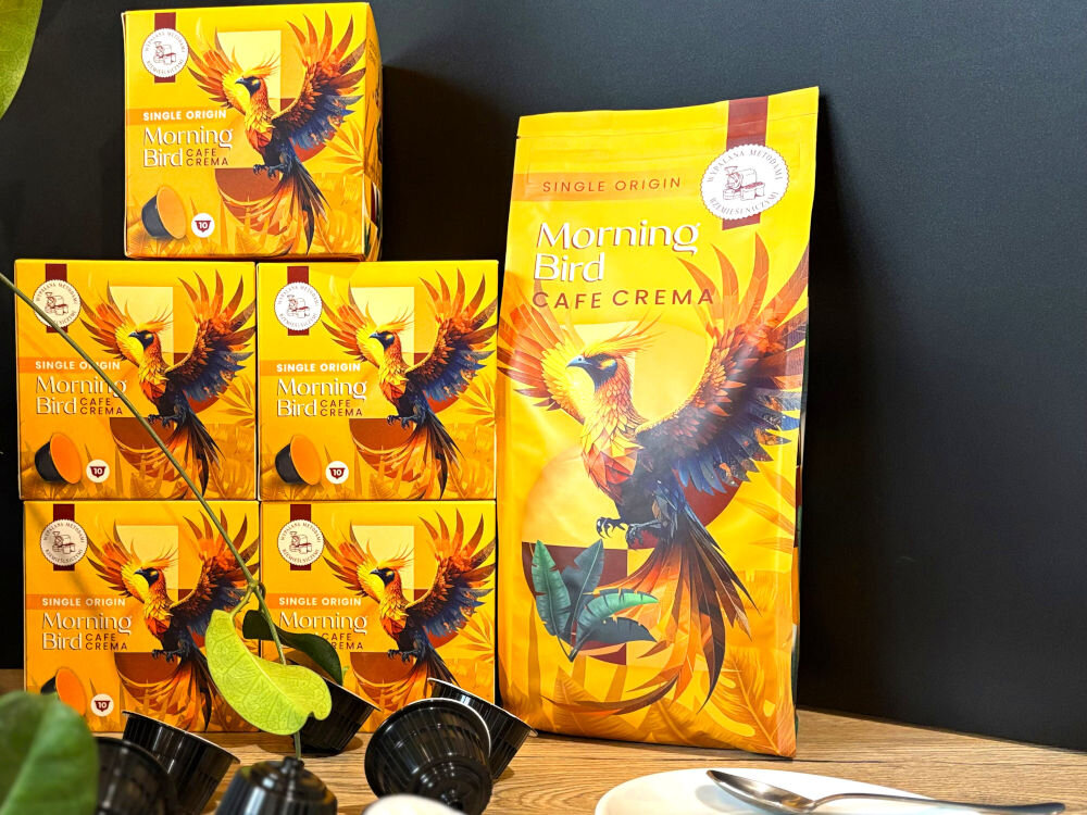 Kapsułki MORNING BIRD Cafe Crema 10 szt. 5 opakowań kawy kapsułkowej a obok opakowanie kawy ziarnistej