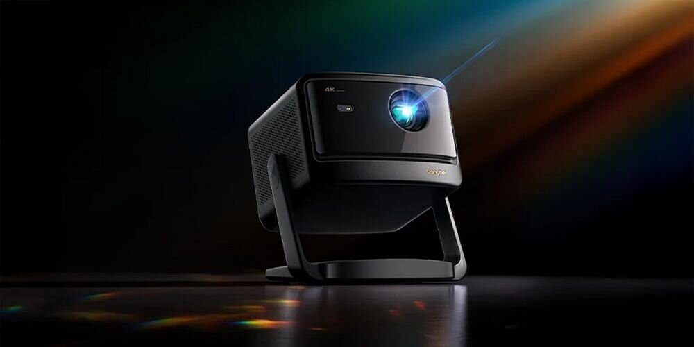Projektor laserowy DANGBEI Mars Pro S2 DBOX02 HDMI 2.1 USB RJ45 SPDIF Bluetooth WiFi 6 Przemyślana konstrukcja, projektor stojący na czarnym blacie na czarnym tle