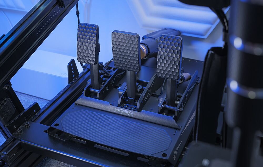 Zestaw pedałów gaz CRP2 + aktywny pedał uniwersalny mBooster MOZA Racing mBooster Pedal Set RS082 (PC) Trzy pedały gazu Moza Racing w pokoju oświetlonym na niebiesko aktywny pedał Moza mBooster aluminium klasy lotniczej włókno węglowe sensor nacisku 15-bitowy czujnik kąta 125 możliwych kombinacji trzystopniowe sprzęgło szybka regulacja wsparcie montażu odwróconego