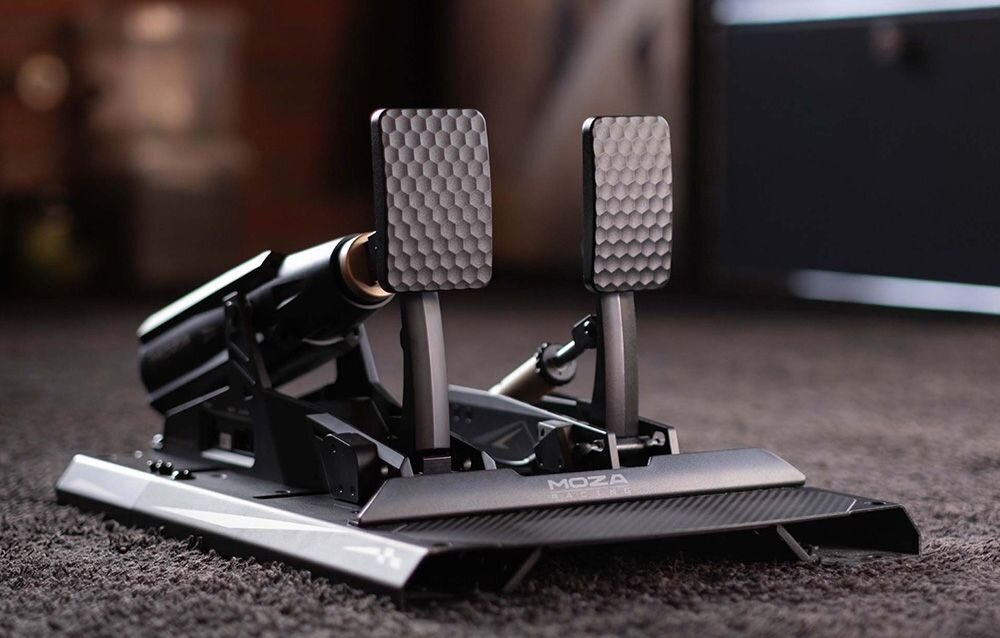 Zestaw pedałów gaz CRP2 + aktywny pedał uniwersalny mBooster MOZA Racing mBooster Pedal Set RS082 (PC) Dwa pedały Moza Racing stojące na brązowym dywanie kompatybilność PC konsole oprogramowanie MOZA Pit House podgląd i regulacja parametrów aktywny pedał mBooster serwo eliminacja tarcia głośność dwa dokładne czujniki