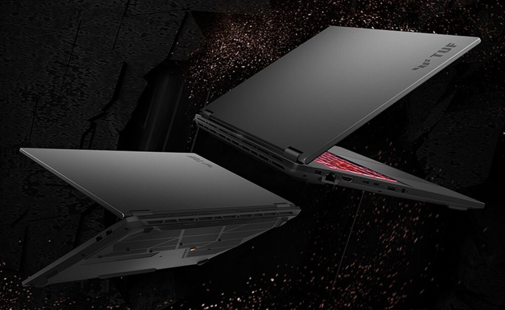 Dwa laptopy ASUS TUF Gaming unoszą się nad ciemnym, pylącym tłem podkreślającym wytrzymałość zgodną z MIL‑STD‑810H – Certyfikat MIL-STD-810H 