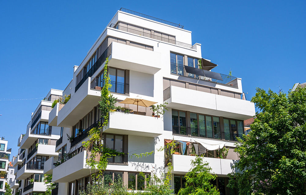 Fotowoltaika balkonowa ECOFLOW Mini Flex, wydajość, niezależne, kanały, MPPT, PV, zdjęcie przedstawia budynek bloku mieszkalnego do którego na jednym z balkonów zainstalowana jest fotowoltaika