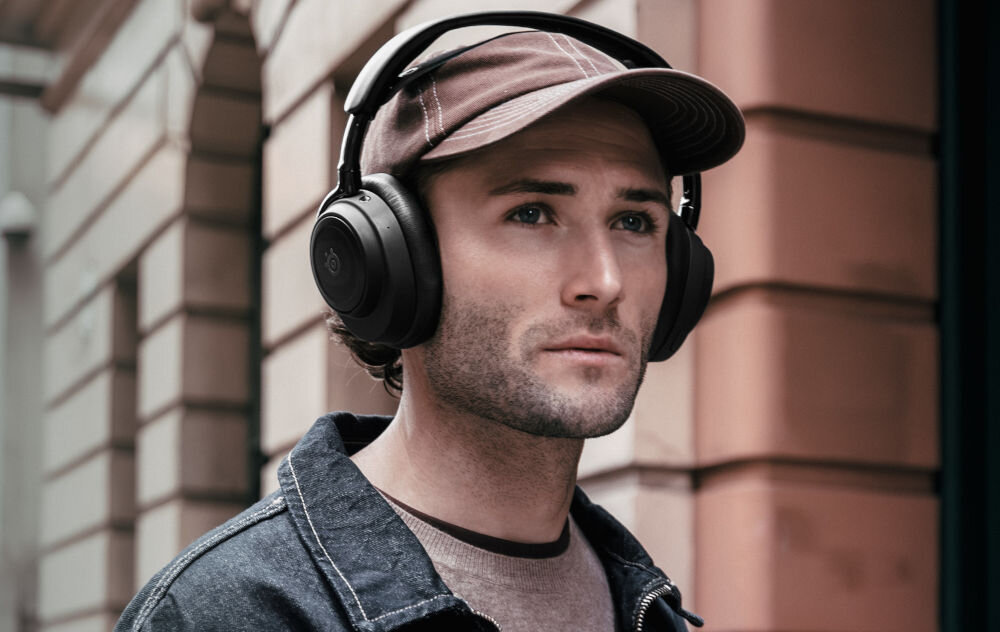 Słuchawki STEELSERIES Arctis Nova Elite bezprzewodowe Hi-Res Audio dla graczy, osoba z założonymi słuchawkami nausznymi