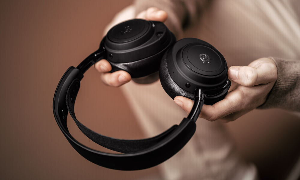 Słuchawki STEELSERIES Arctis Nova Elite Hi-Res Audio Bluetooth LE Audio LC3+, osoba trzymająca słuchawki w rękach