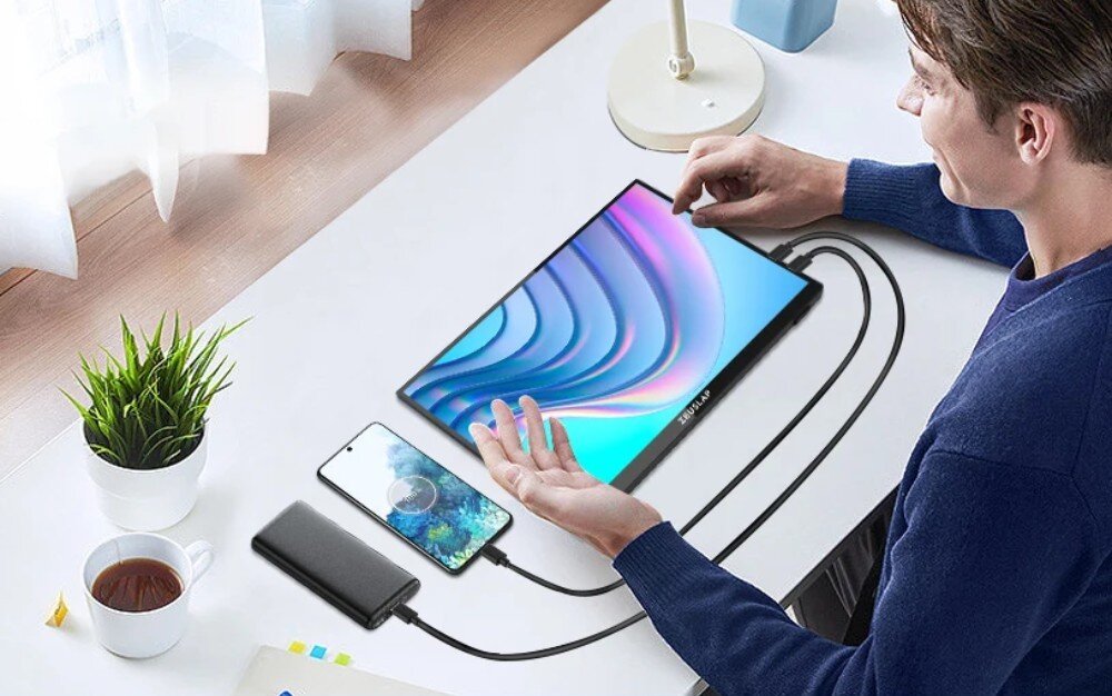 Monitor ZEUSLAP P16KT Osoba siedząca przy biurku, korzystająca z monitora przenośnego podłączonego do smartfona i powerbanka, obok kubek kawy i doniczka z rośliną, tryby wyświetlania, czas reakcji matrycy