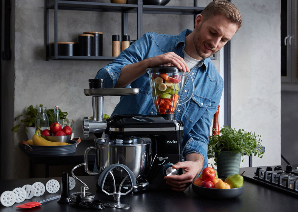 Robot kuchenny planetarny LOVIO HOME ChefAssistant Plus LVSTM02PRD 1900W z blenderem kielichowym i maszynką do mięsa mężczyzna blenduje owoce za pomocą pokrętła akcesoria końcówki kuchnia szpatułka moc 1900 W wszechstronność funkcjonalność funkcje ubijania mieszanie zagniatanie misa ze stali nierdzewnej pojemność 6,2 litra ergonomiczny uchwyt miarka kontrolowanie ilości składników obroty planetarne równomierne połączenie składników