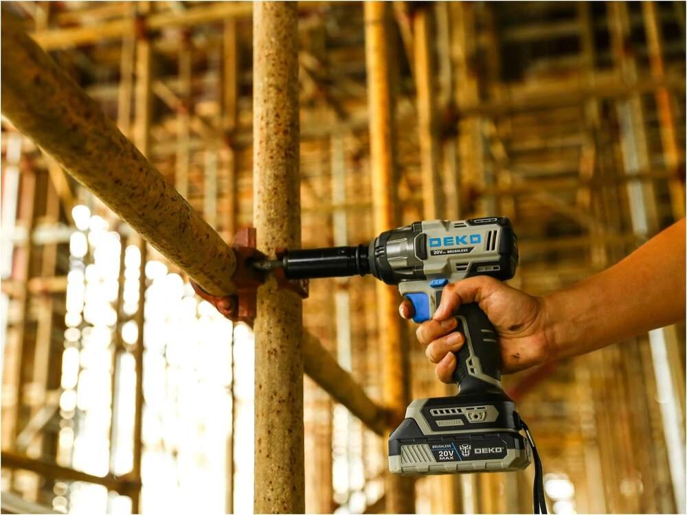 Klucz udarowy DEKO DKBW20XL01-S3, Bezszczotkowy silnik, Osoba dokręca śrubę konstrukcji budowlanej w tle reszta konstrukcji