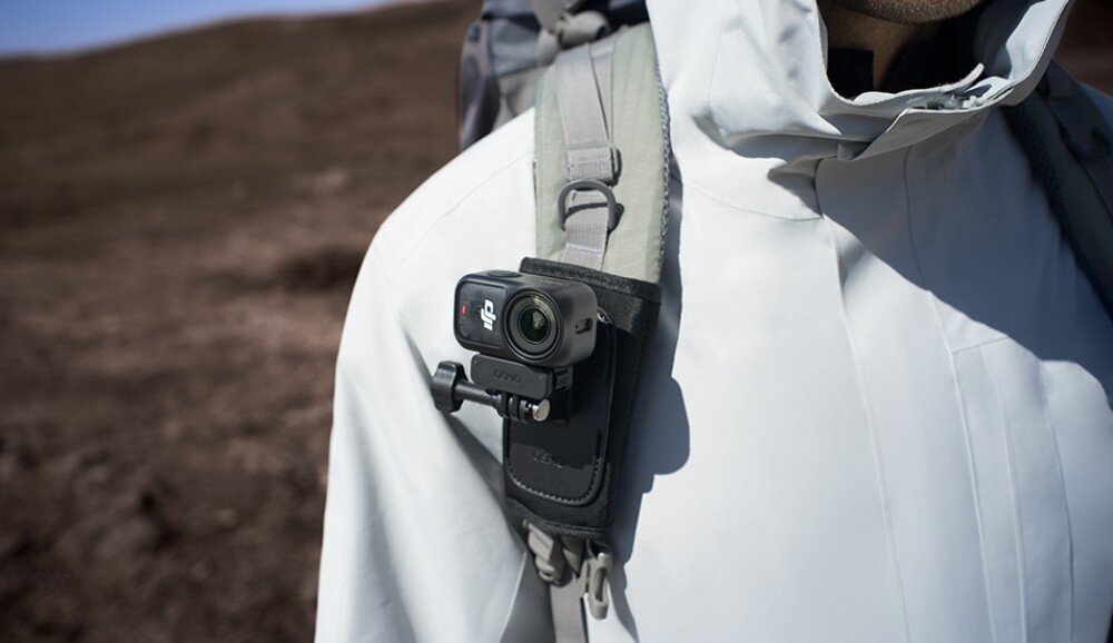 Kamera sportowa DJI Osmo Nano Kamera sportowa zamocowana na pasku plecaka osoby w jasnej kurtce, tryby nagrywania, funkcje, sterowanie gestami
