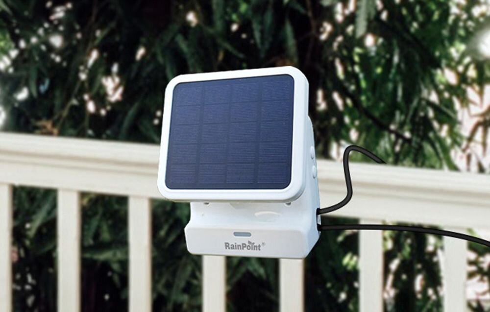 Zestaw do nawadniania RAINPOINT HTP115FR + HWG023WBRF, system nawadniania, smart ogród, automatyka, rośliny, Biały panele solarny zamocowany przy poręczy na tle roślin.