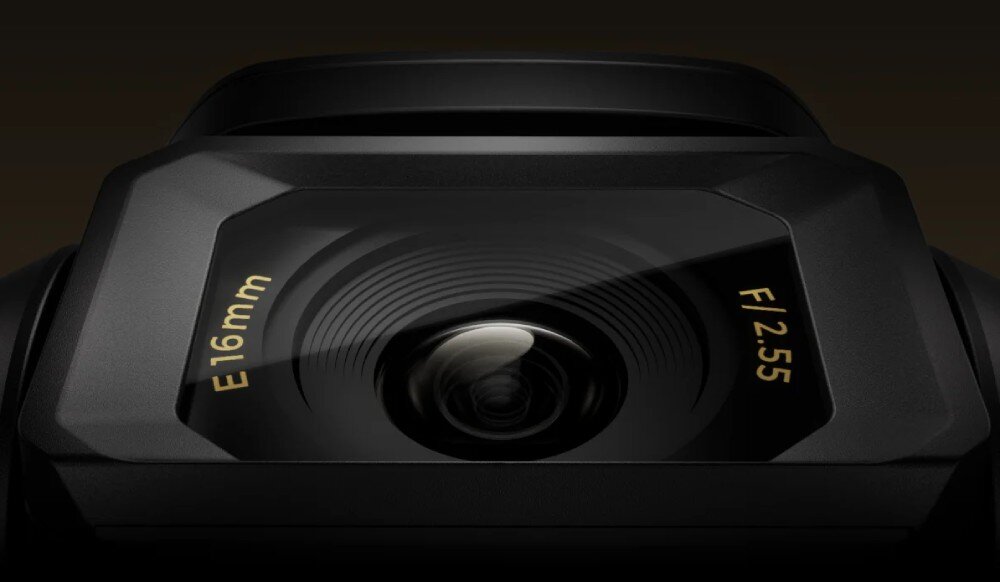 Dron HOVERAIR X1 Promax Zbliżenie na szerokokątny obiektyw kamery z napisem E 16mm i oznaczeniem jasności F/2.55 na czarnym tle, zdjęcia, wbudowana pamięć