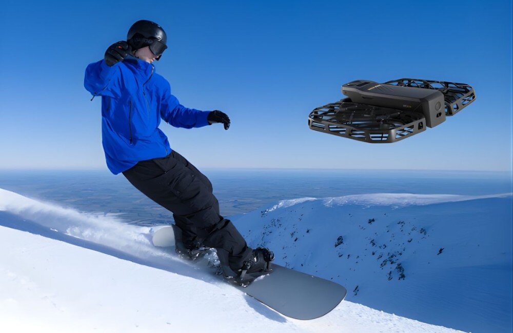 Dron HOVERAIR X1 Pro Basic Combo Snowboardzista zjeżdżający po ośnieżonym zboczu i towarzyszący mu w locie czarny dron, odporność, temperatury