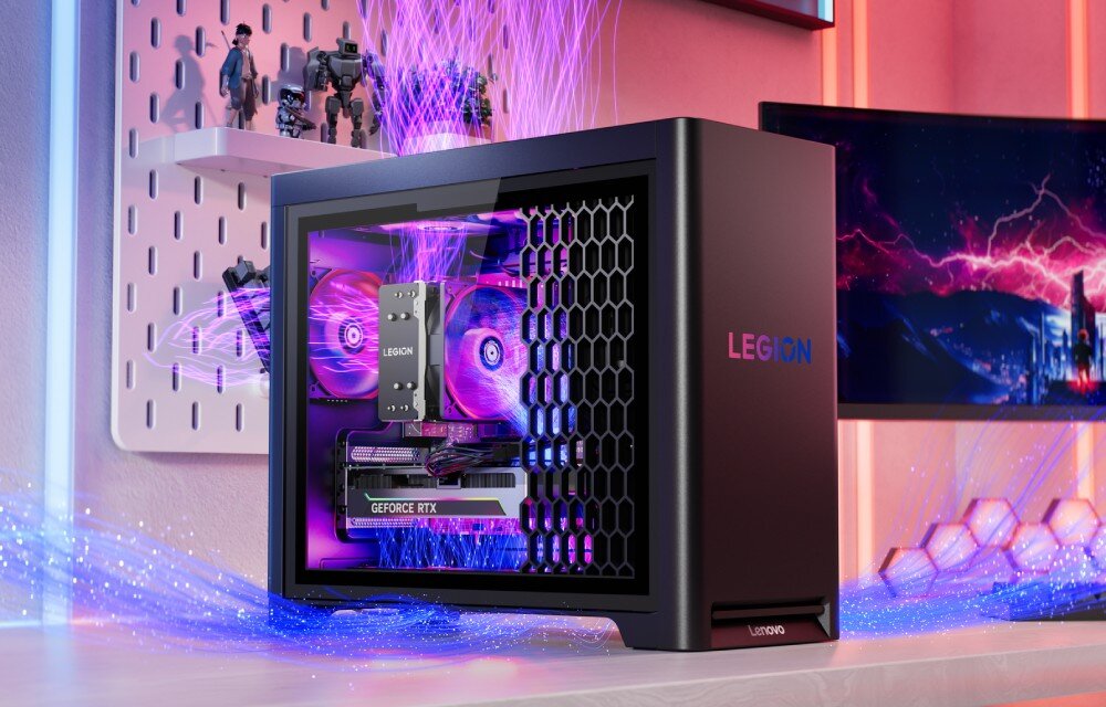 Komputer LENOVO Legion T5 30AGB10 Komputer z przezroczystym bokiem i podświetlonymi wentylatorami w kolorze fioletowym ustawiony na biurku obok monitora