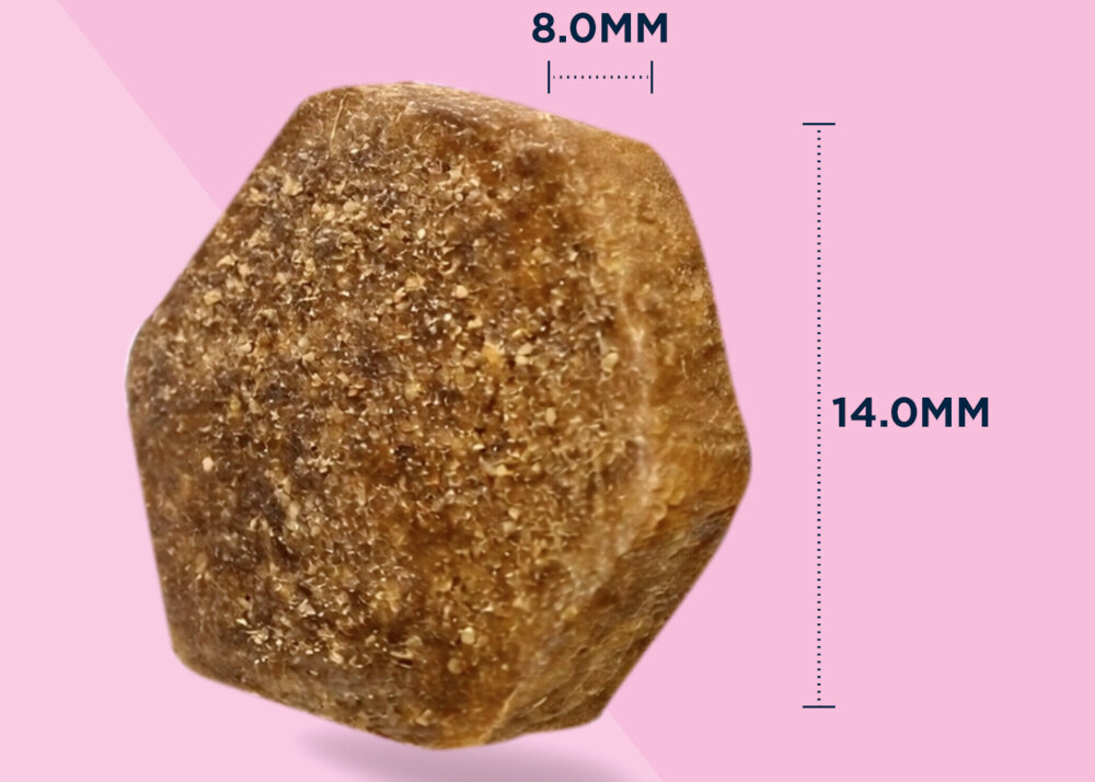 Brązowy, sześciokątny kawałek karmy o wymiarach 8.0 mm na 14.0 mm na różowym tle.