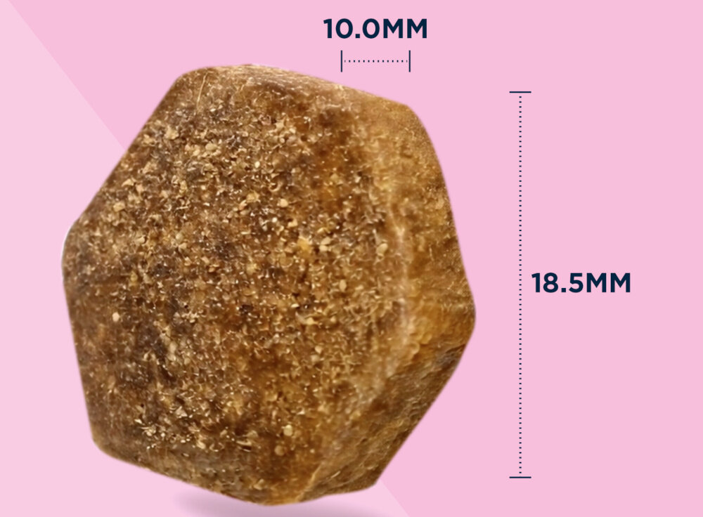 Zdjęcie przedstawia brązowy, sześciokątny kawałek karmy na różowym tle. Obok widoczne są wymiary: 10.0MM i 18.5MM.