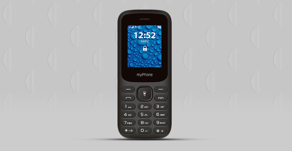 Na obrazie widoczny jest czarny telefon z klawiaturą numeryczną i małym ekranem, na którym wyświetlana jest godzina 12:52 oraz data 10/02. Na obudowie pod ekranem znajduje się napis \'myPhone\'.