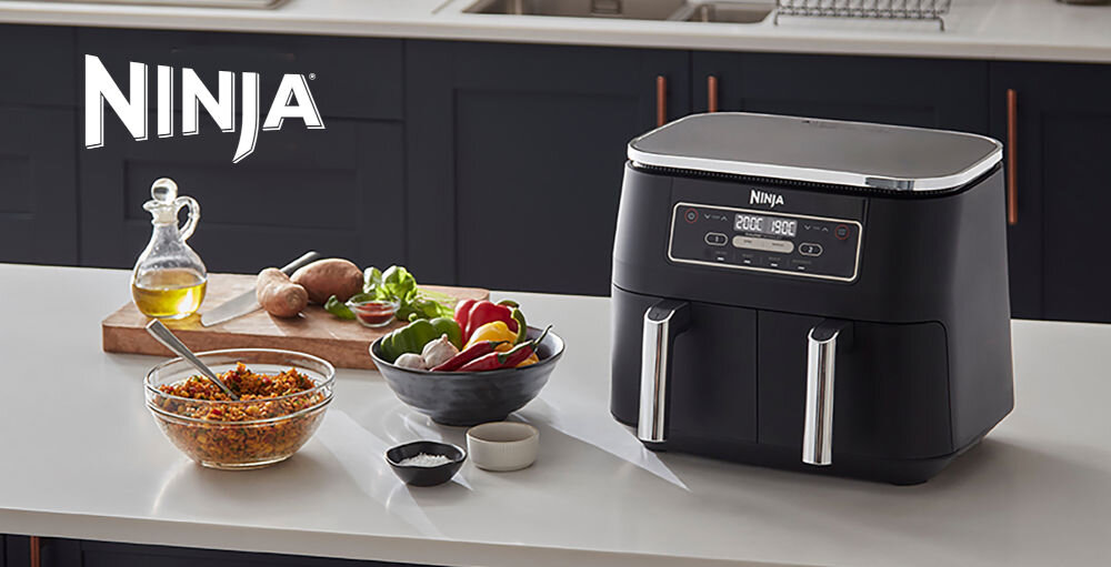 Air Fryer Frytkownica beztłuszczowa NINJA AF200EU z podwójnym koszem kuchenne tło ciemne szafki frytkownica stojąca na blacie dwa kosze przyciski warzywa w misce warzywa na desce