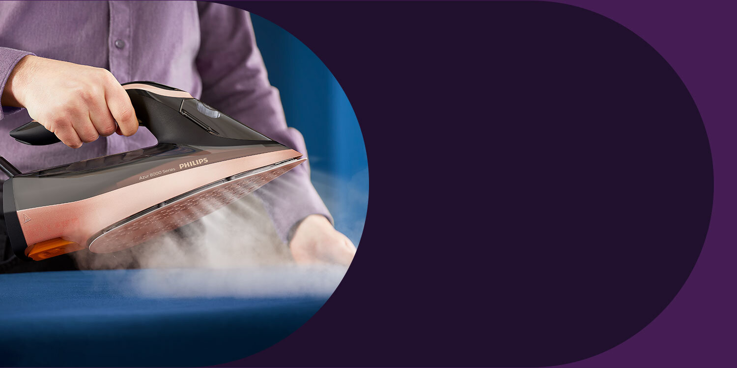 Osoba prasuje niebieski materiał żelazkiem z widocznym napisem \'PHILIPS\'. Z żelazka wydobywa się para.