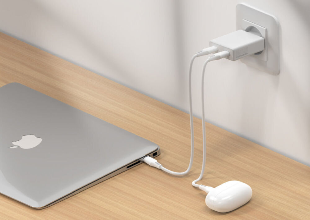 4SMARTS PDPlug Slim Dual 65W GaN Cienka obudowa płaska konstrukcja ciasnych gniazdek 80 g - łądowarka w gniazdku, podłączony laptop oraz słuchawki