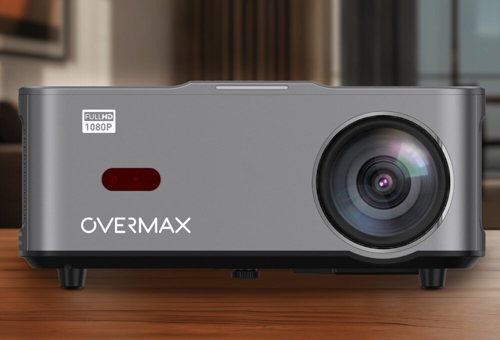 Na obrazie widoczny jest projektor z dużym obiektywem po prawej stronie. Na obudowie znajduje się napis \'OVERMAX\' oraz oznaczenie \'FULL HD 1080P\'.