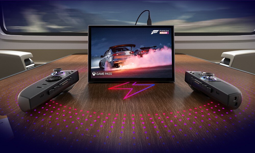 Konsola LENOVO Legion Go 2 Ekran stojący na drewnianym stole, obok leżą dwa oddzielne kontrolery. Całość oświetlona fioletowo-niebieskim światłem z podłoża, bateria, ładowanie, moc