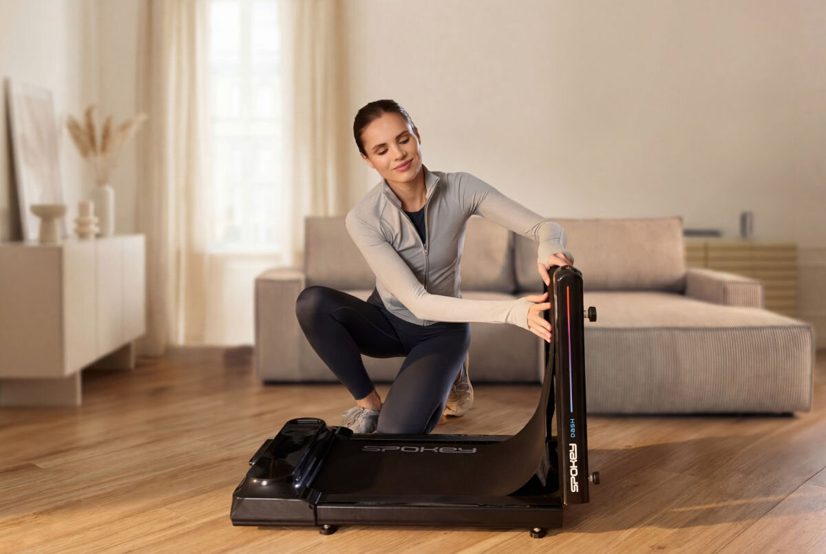 Bieżnia elektryczna SPOKEY Dash 932W 6 km/h, ergonomia, mobilność, oszczędność, praktyczność, Kobieta składa bieżnię Spokey do pionowego przechowywania