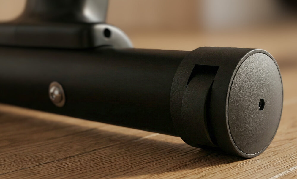 Rower magnetyczny SPOKEY Dust drewniana podłoga zbliżenie na kółka transportowe wymiary 105 × 52 × 145 cm waga około 32 kg konstrukcja stabilna łatwa do przesunięcia kółka transportowe umieszczone z przodu